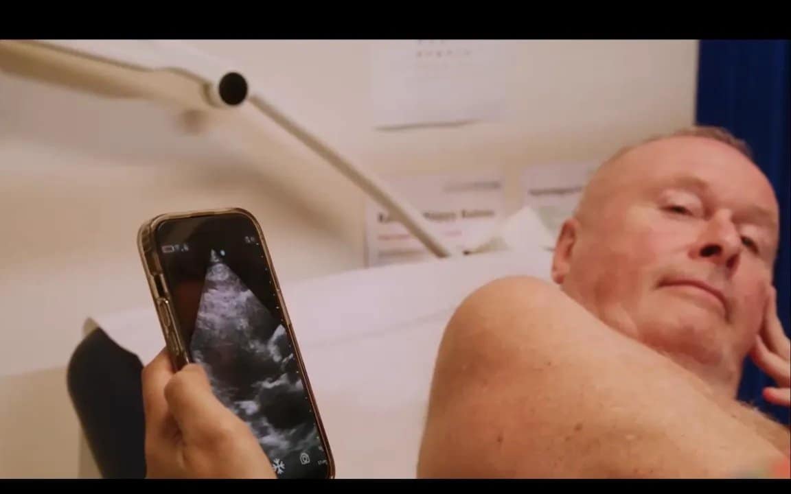 Vscan Air Erfahrungen in UK: Wie Handheld-Ultraschall Herzprobleme früh erkennt 2 Smartphone mit echokardiogramm-ansicht neben liegendem Patienten, Hand hält Gerät